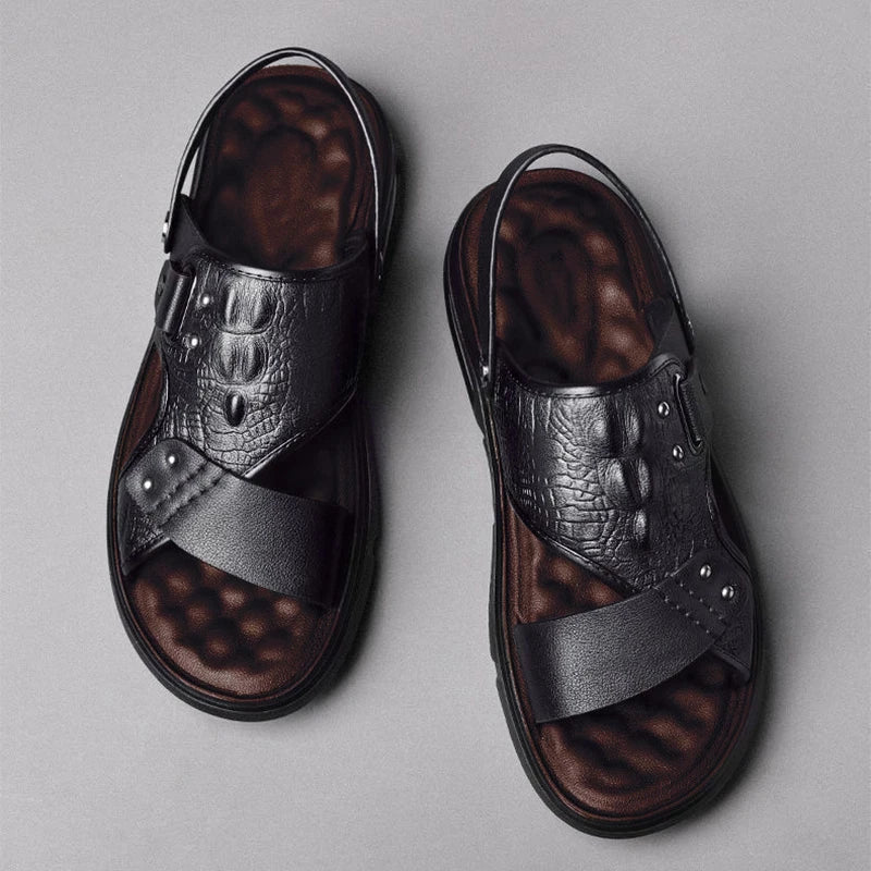 Pair of black and brown sandals on a gray background