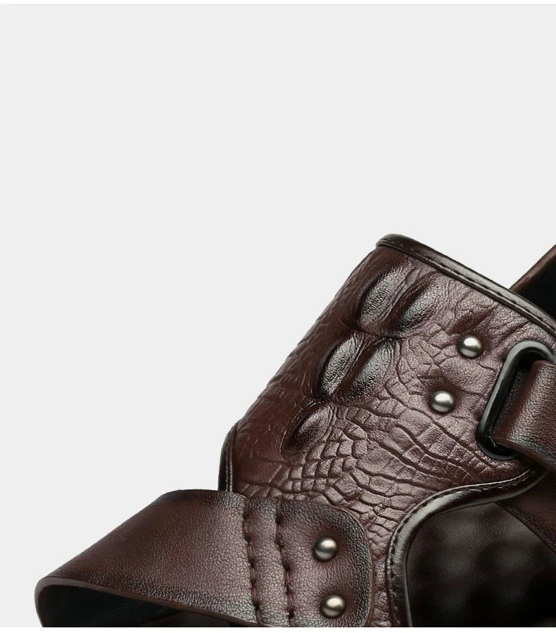 Close-up of a brown leather boot with metallic studs on a light gray background